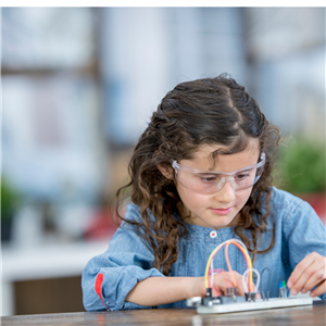 Young girl with safety glasses building a science experiment