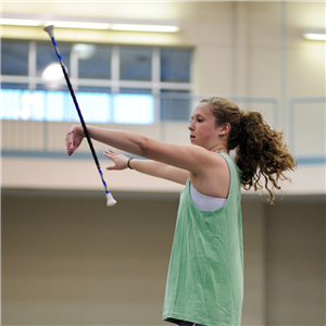Girl in a gym twirling a baton 